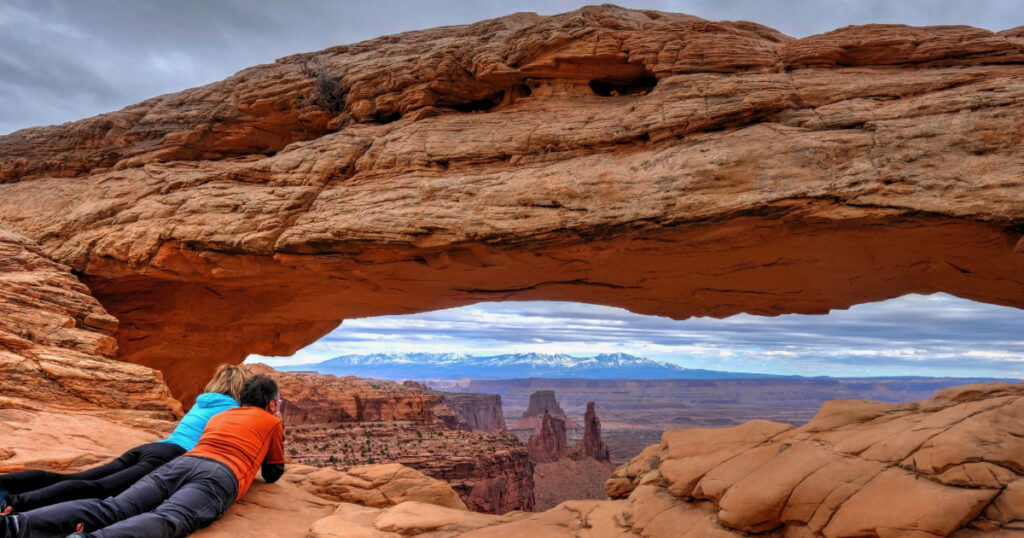 Shutterstock Tourists enjoying the view of Mesa Arch. Canyonlands National Park. Moab. Utah. US