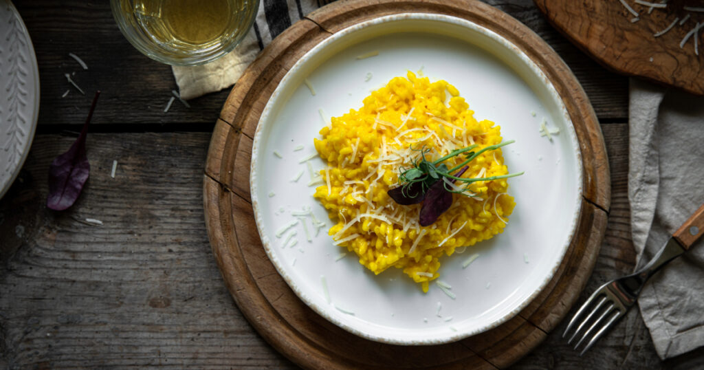 Shutterstock Rustic dinner. Risotto Milanese(saffron risotto) in white plate