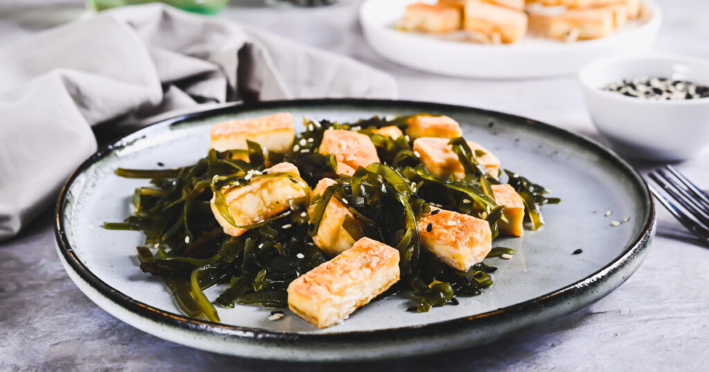 Shutterstock Vegetarian fried tofu and seaweed salad on a plate on the table