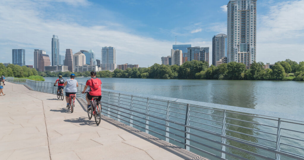 Shutterstock People biking along Colorado River waterfront boardwalk near downtown Austin, Texas