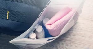 Set of travel bottles and towel in plastic bag
