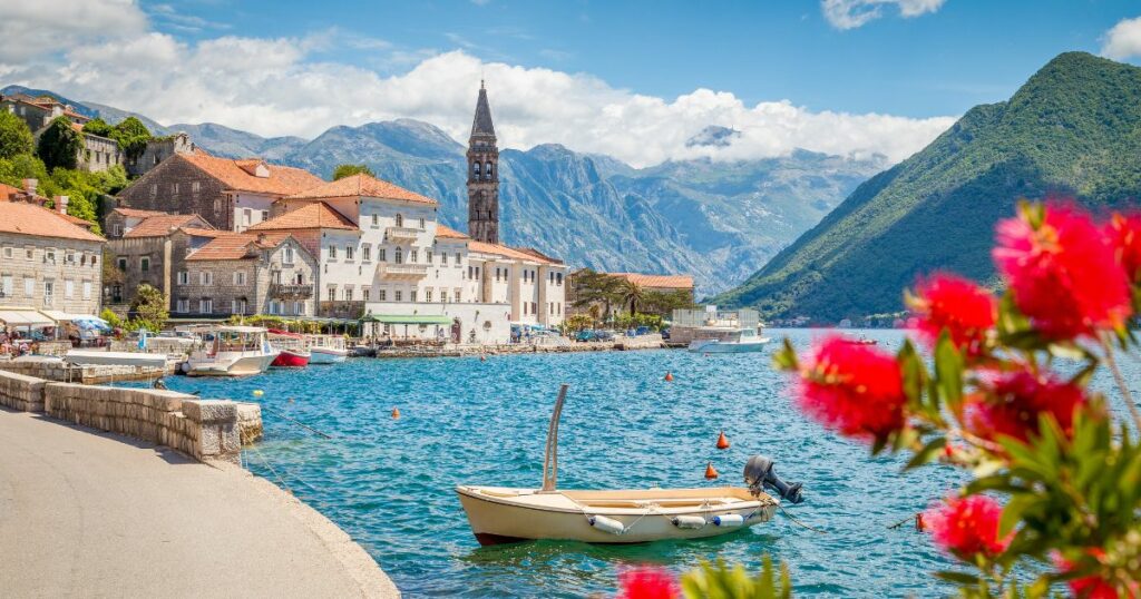 Shutterstock Scenic panorama view of the historic town of Perast at famous Bay of Kotor with blooming flowers on a beautiful sunny day with blue sky and clouds in summer