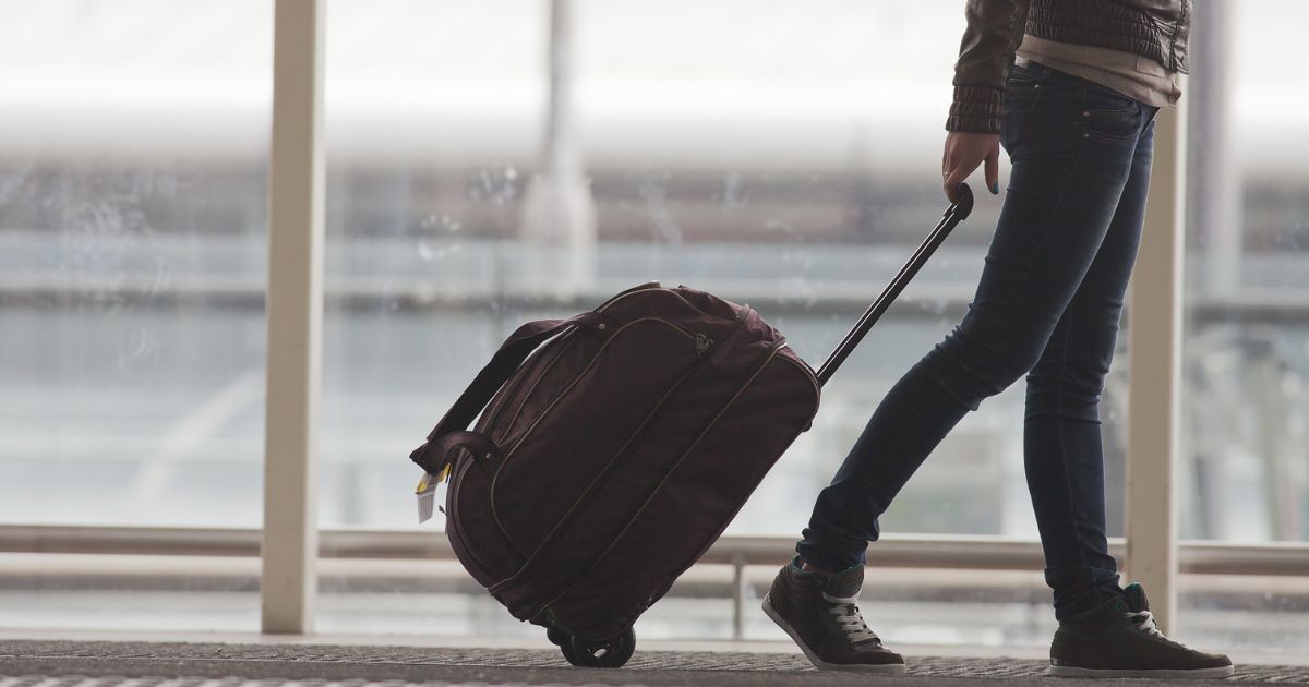 Woman carries your luggage at the airport terminal of Hong Kong