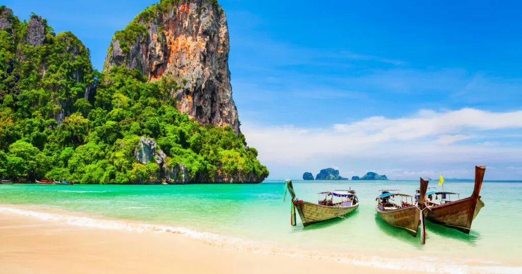 Shutterstock Boats at the Railay beach with limestone cliff and crystal clear water in Thailand
