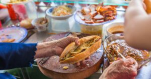 Woman selling street food Banh Mi at vendor in Vietnam