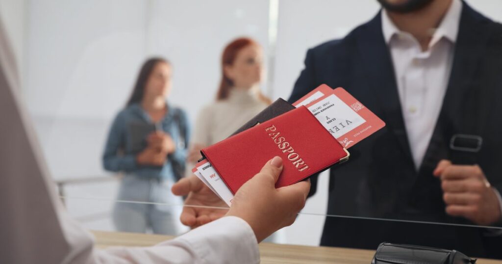 Shutterstock Agent giving passports with tickets to client at check-in desk in airport