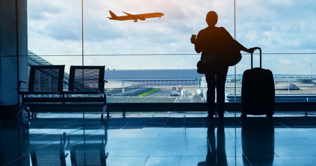 Shutterstock A person looking at a plane flying by in an airport