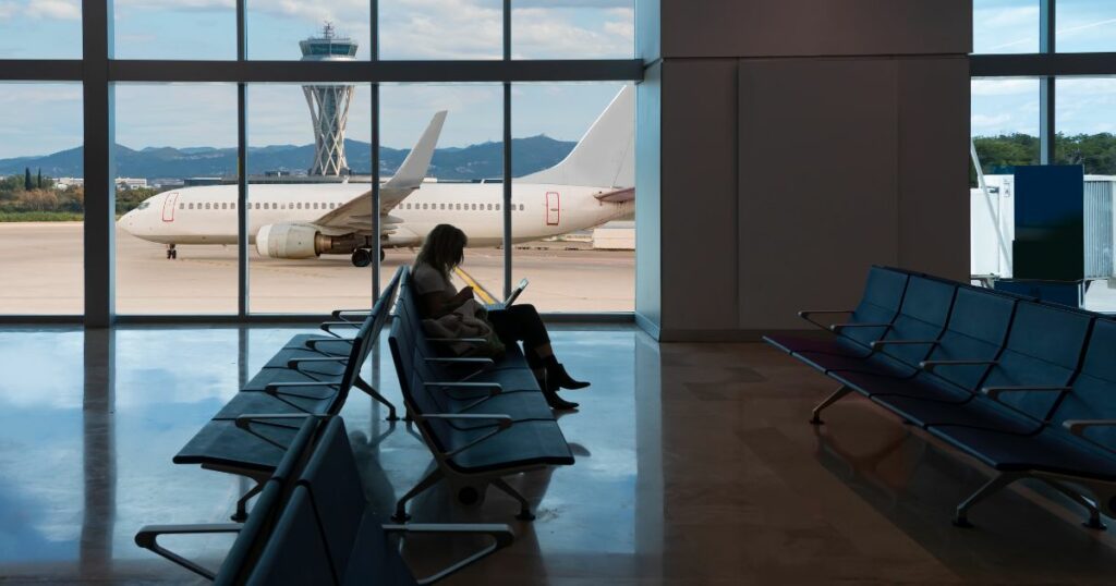 Shutterstock Silhouette of young woman working on laptop and waiting for flight in the airport