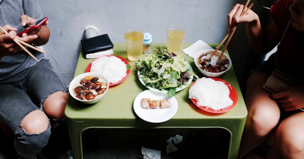Shutterstock People eating street food on sidewalk in Hanoi