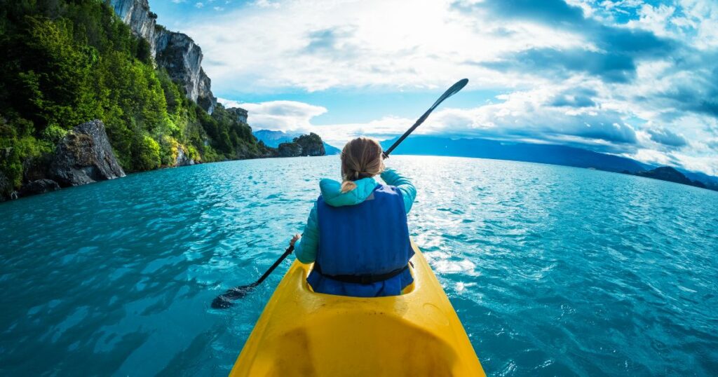 Shutterstock Woman paddles kayak in the lake with turquoise water. Patagonia, Chile