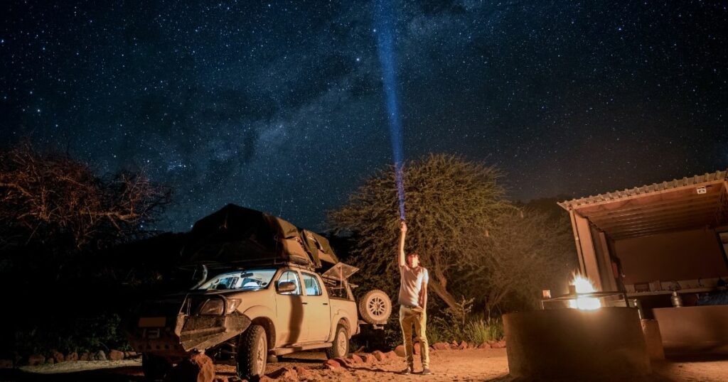 Shutterstock A male traveler at a campsite, stargazing in Namibia