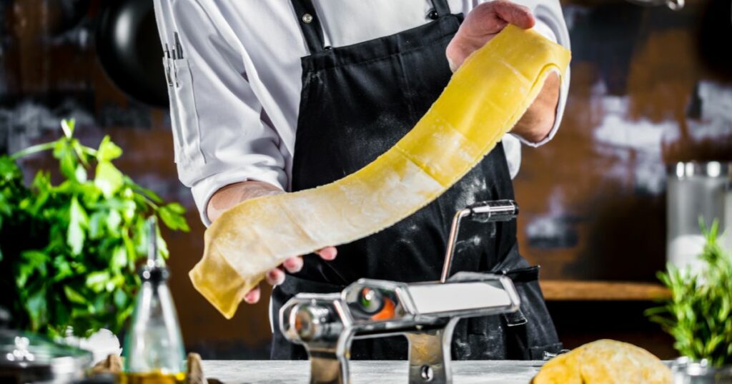 Shutterstock Chef making spaghetti noodles with pasta machine on kitchen table