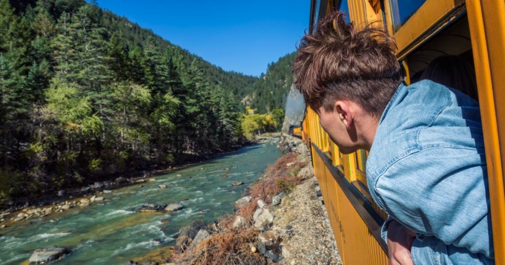 Shutterstock Young man looking out of train window on the historic steam