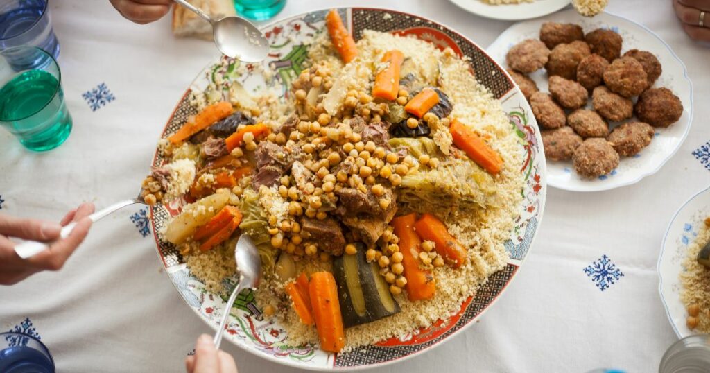 Shutterstock Big plate of cous cous being eaten by various hands around the table