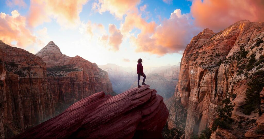 Shutterstock Adventurous Woman at the edge of a cliff is looking at a beautiful landscape view in the Canyon