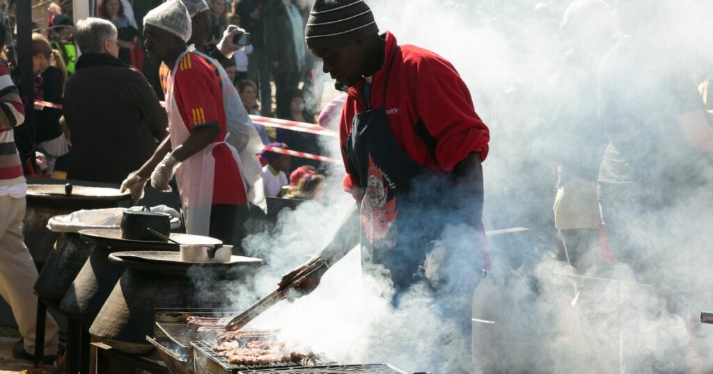 Male chef vendor working a BBQ grill 