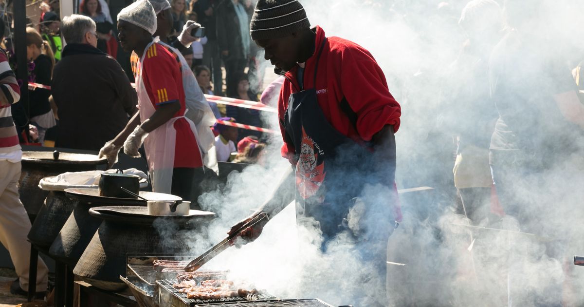Male chef vendor working a BBQ grill