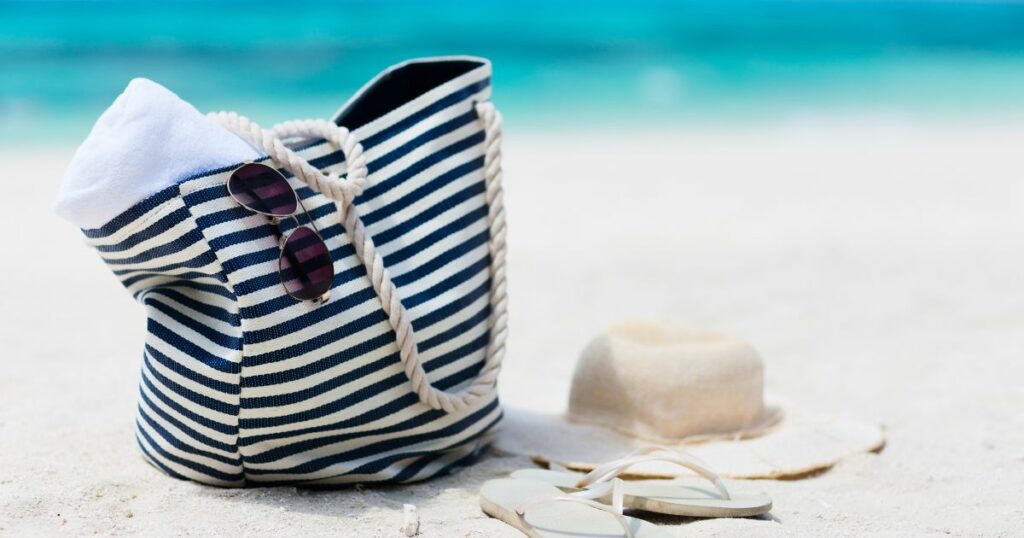 Shutterstock Straw hat, bag, sun glasses and flip flops on a tropical beach