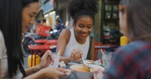 A group of young ladies eating local food together