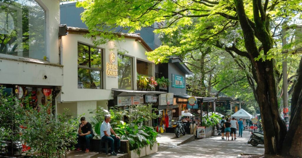 Shutterstock Street scene in the Poblado district, with people walking, shops, bars, restaurants and tropical vegetation