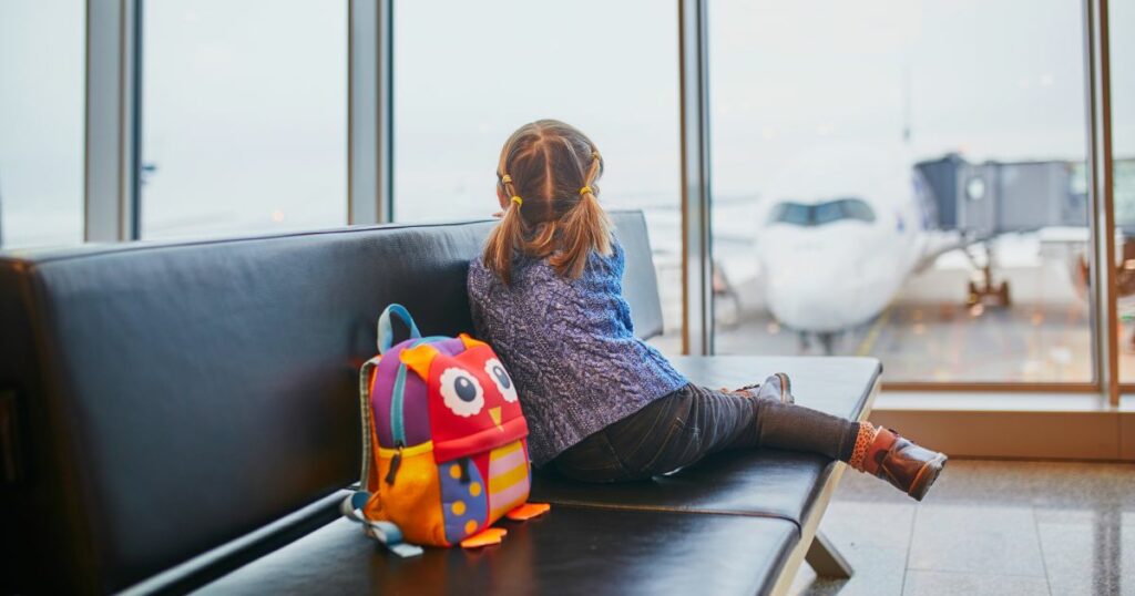 Shutterstock A child sitting alone at an airport waiting for her flight