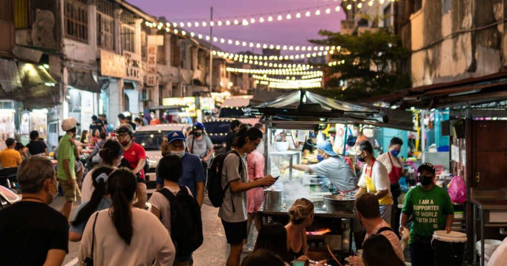 Shutterstock Tourists and locals enjoying food in Penang street food market