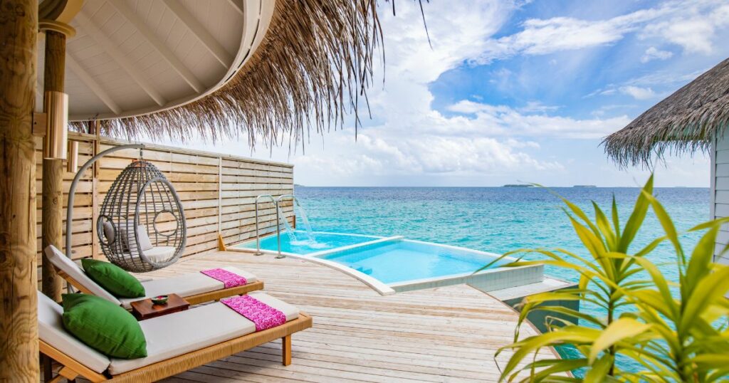 Shutterstock Fantastic over water villa, terrace view with sun beds chairs under umbrella, luxury pool hotel with stunning ocean view. Beautiful spa or wellness concept, recreational vacation resort tranquil area