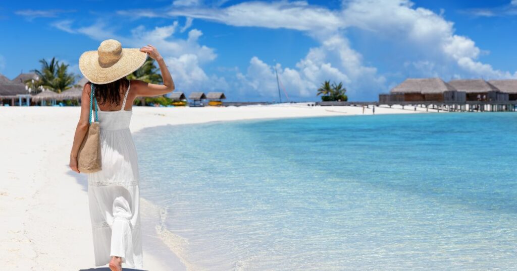 Shutterstock A woman with a cloth tote bag walking on the shore in Maldives
