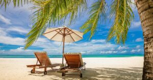 Beautiful panoramic sea sand sky. Tropical relax beach sunny summer island landscape. Love couple chairs umbrella palm leaves romantic coast. Luxury travel destination. Honeymoon vacation best holiday