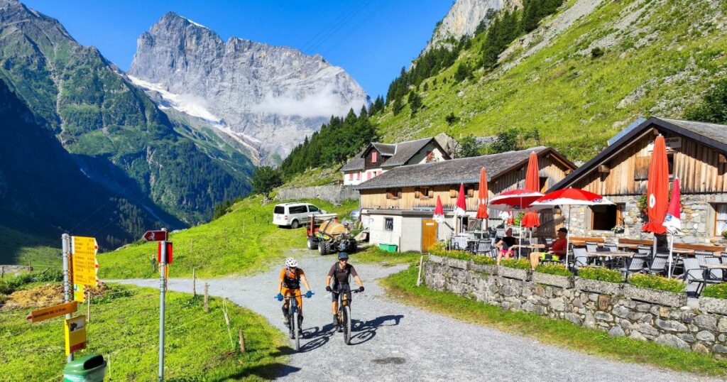 Shutterstock Mountain bikers in front of a farmhouse over Engelberg on the Swiss alps