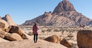 Woman standing looking at Spitzoppe, Namibia