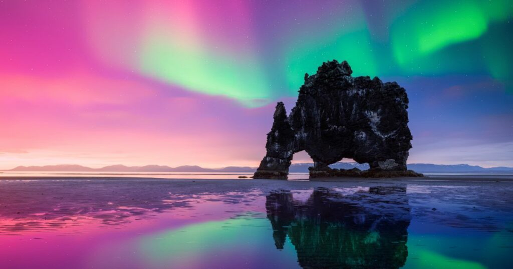 Shutterstock Purple and green Northern lights over Basalt stack Hvitserkur on the Vatnsnes peninsula, Iceland.