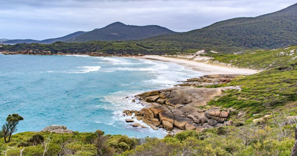Shutterstock Scenic view of Squeaky Beach with green hills on a cloudy day, Wilsons Prom, Australia