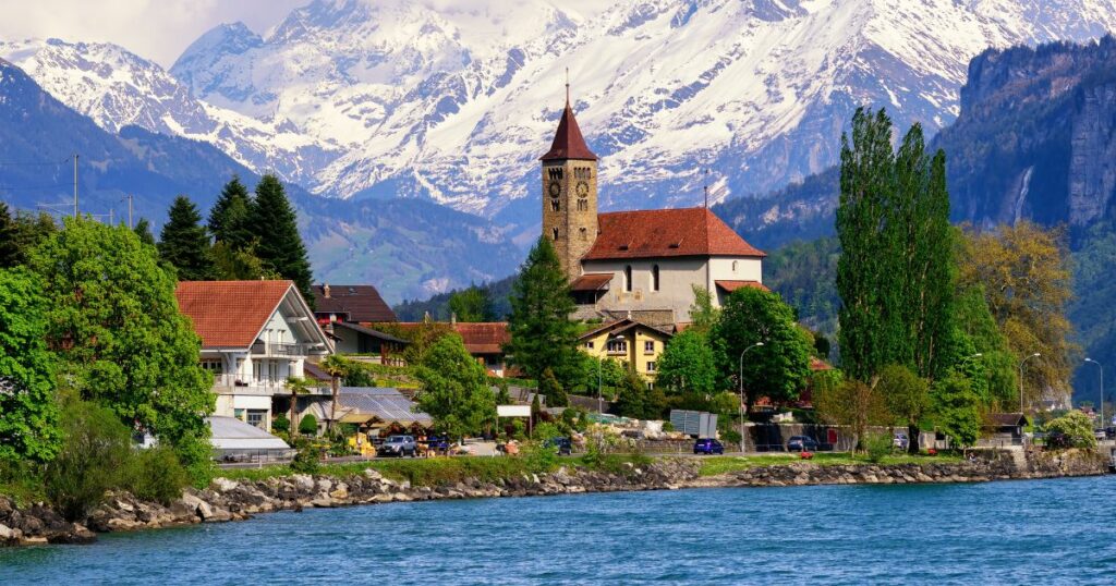 Shutterstock Brienz town on Lake Brienz by Interlaken, Switzerland, with snow covered Alps mountains in background
