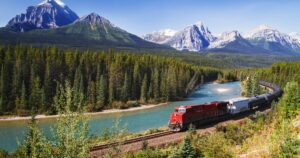Train passing through Bow valley under the surveillance of mighty Rocky Mountains