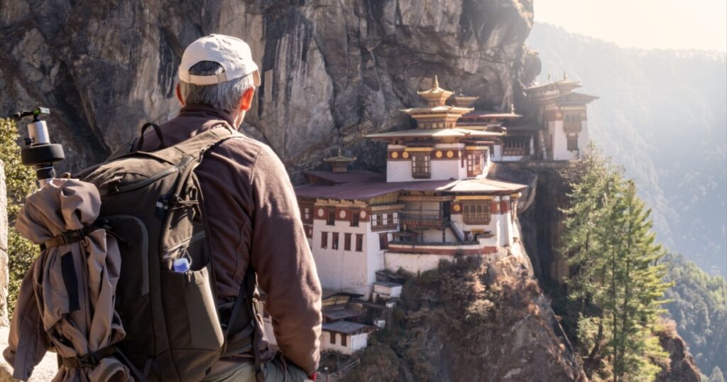 Tourist sitting on his back watching tiger`s nest temple in Paro, Bhutan