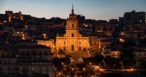 Panorama of the ancient baroque town Modica and cathedral San Giorgio at night with street lights, Sicily, south Italy