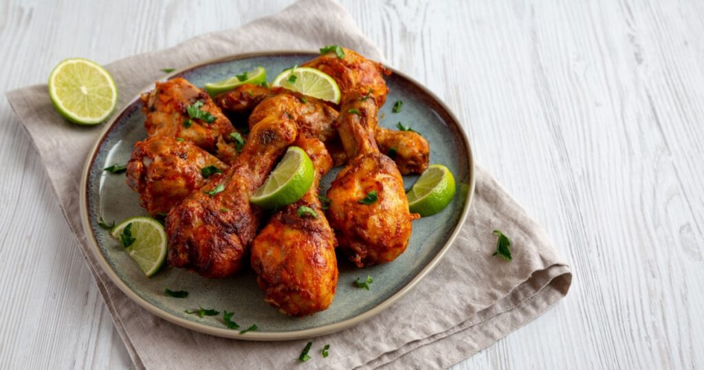 Homemade Grilled Jerk Chicken with Lime on a Plate, side view
