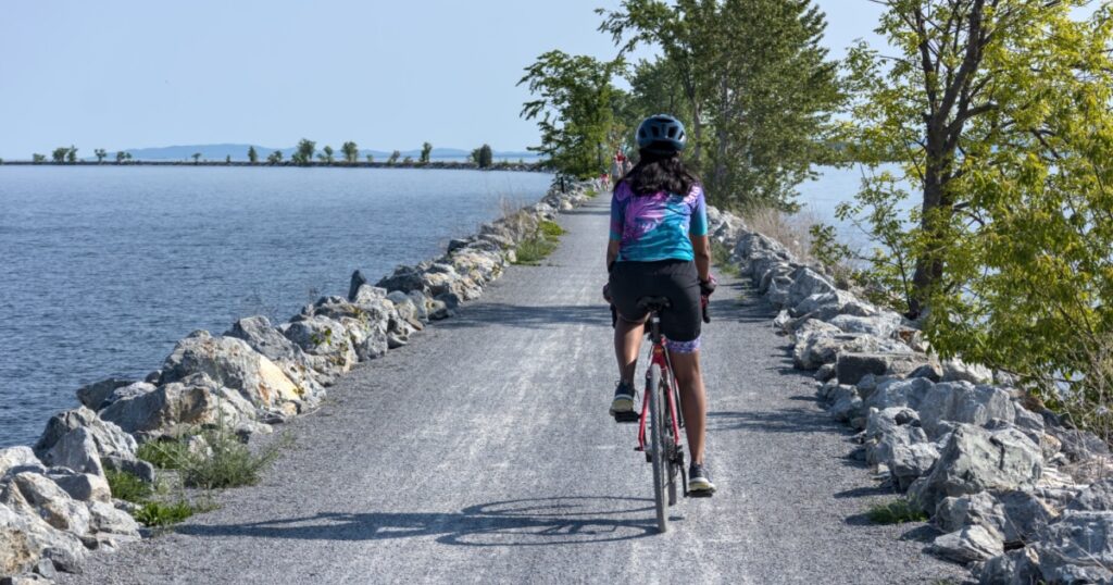 Woman riding a bicycle on the colchester causeway in Vermont