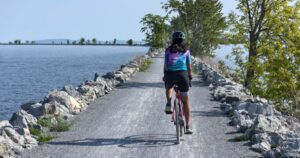 Woman riding a bicycle on the colchester causeway in Vermont