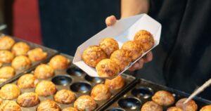 A photo of takoyaki being grilled at a food stall