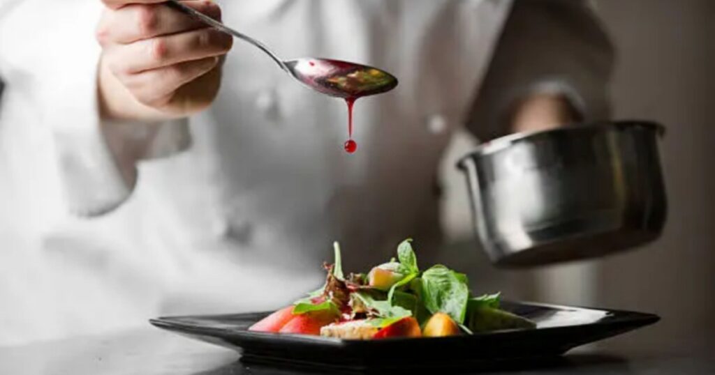 High resolution image of a chef putting sauce on dish
