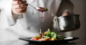 High resolution image of a chef putting sauce on dish