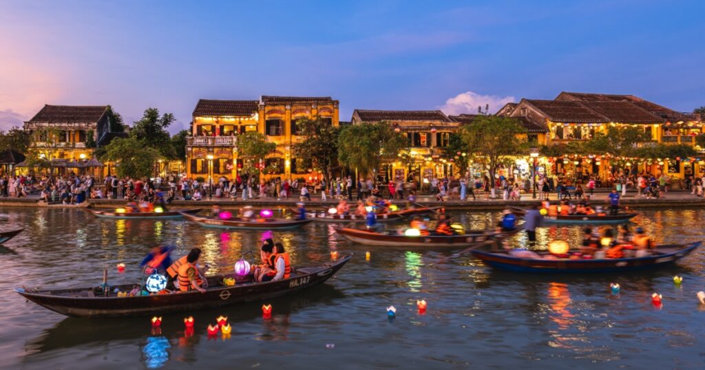 People ride boats and release paper flower lanterns at Thu Bon River in the Hoi An ancient town, Vietnam at night