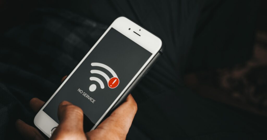 Man holding phone showing no wifi service