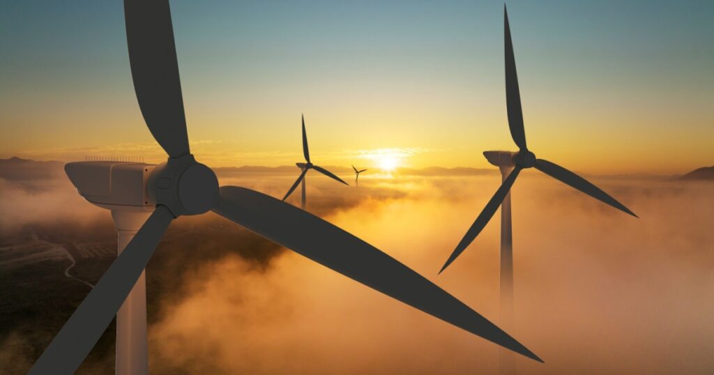 Wind turbine silhouette at sunrise, wind energy and nature concept.