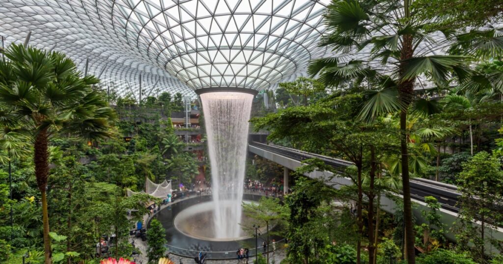 Parallax view of indoor Singapore rain vortex dome waterfall in rain forest Jewel Changi Airport Singapore