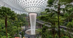 Parallax view of indoor Singapore rain vortex dome waterfall in rain forest Jewel Changi Airport Singapore