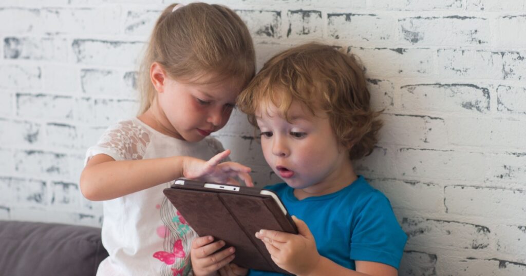 Brother and sister playing games on tablet