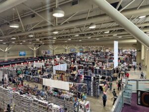 An overhead view of Fan Expo’s exhibitor hall, filled with rows of merchandise booths and wandering attendees.